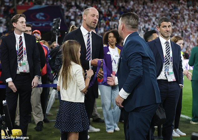 And in a sweet moment (pictured), the Prince was given two winners medals to keep after the presentation - and starstruck Charlotte could not wait to get a proper look at them