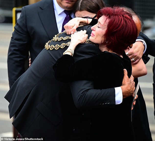 Sharon Osbourne hugs Lord Mayor of Birmingham Councillor Zafar Iqbal as she looks at tributes left to her late husband