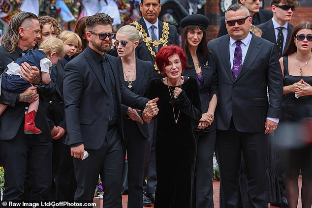 Jack Osbourne holds his mother's Sharon's hands as the procession makes its way through Birmingham