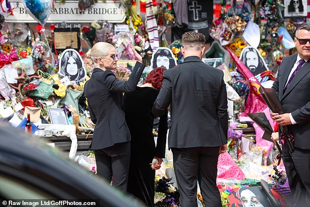 Kelly waves to fans who packed the streets to view her father's funeral procession