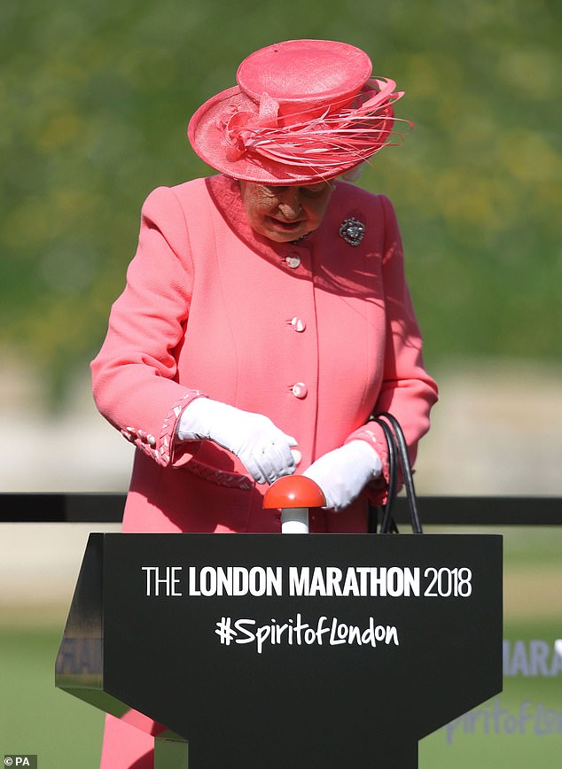 Wearing a bright pink outfit, Queen Elizabeth II stepped onto a special podium on the empty grounds of Windsor Castle