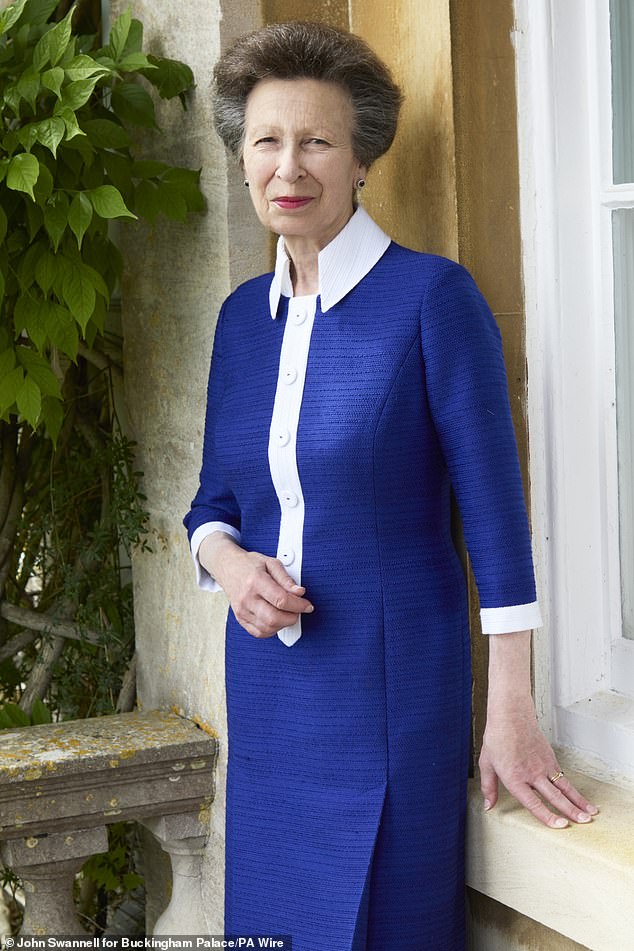 The photograph released to mark the Princess Royal's 75th birthday - Princess Anne wears a blue and white dress while leaning by a windowsill at her private residence, Gatcombe Park