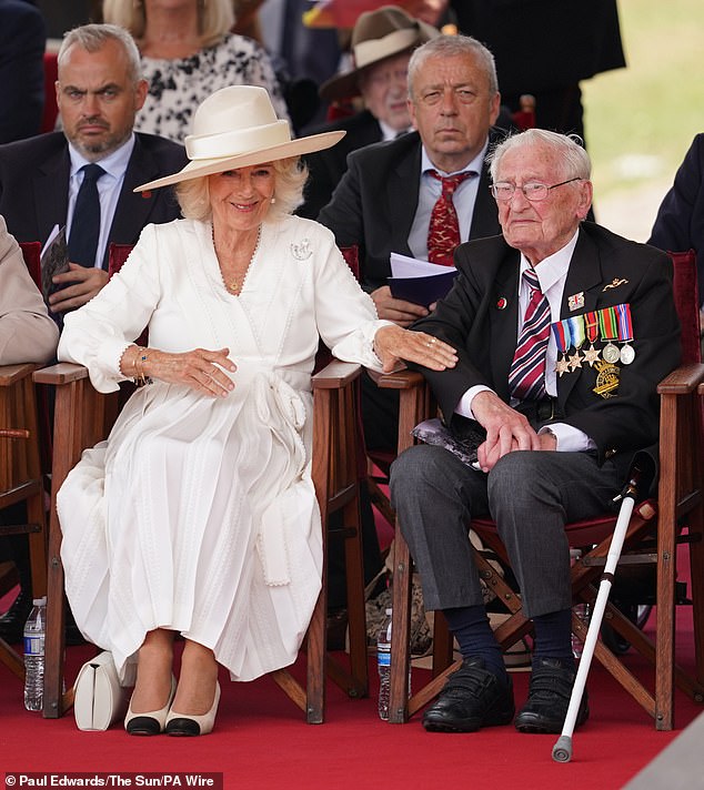 Queen Camilla spent the service sitting next to former Royal Navy submarine telegraphist, John Harlow, aged 100 (right)