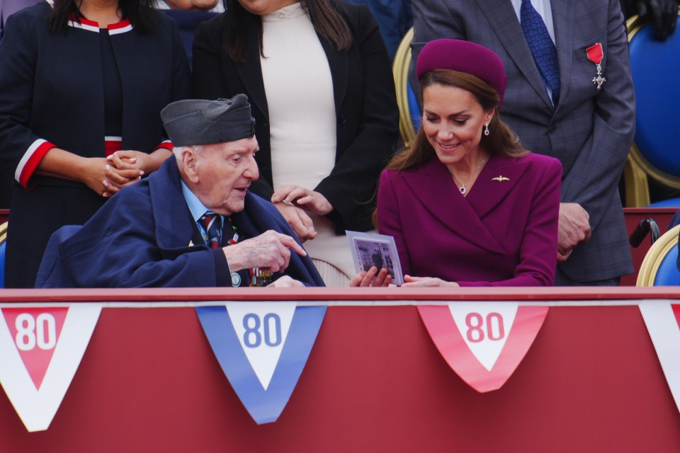 The Princess of Wales looking at a photo with a World War II veteran at a VE Day anniversary event.