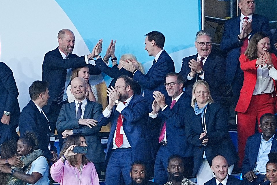 The Prince of Wales and Princess Charlotte celebrating with other officials at a soccer game.