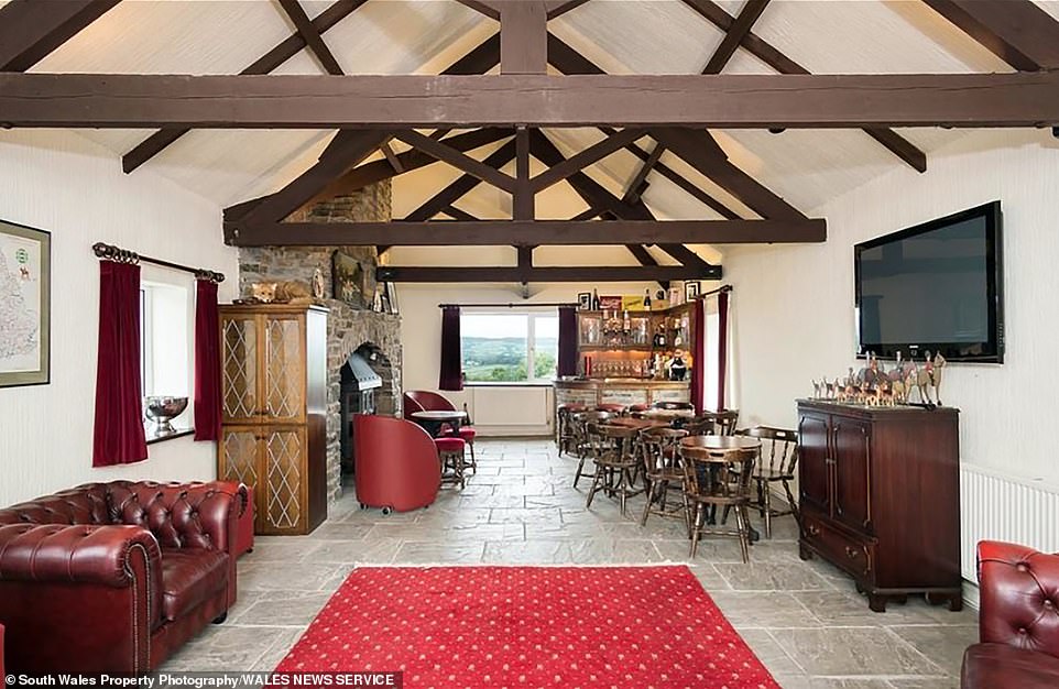 Pictured: The bar at Llwynddu House, which opens up into a sitting area, offering the perfect space in which to entertain guests at the mansion in the Vale of Glamorgan. Fans of the singer - who lived at the property for 10 years - are now able to buy the house for £2.6 million