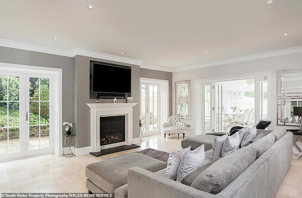 The house features sprawling, airy rooms throughout, offering tranquil views of the surrounding countryside in Cowbridge. Pictured: The living room of the five-bedroom mansion in the Vale of Glamorgan, leading into the home's dining area