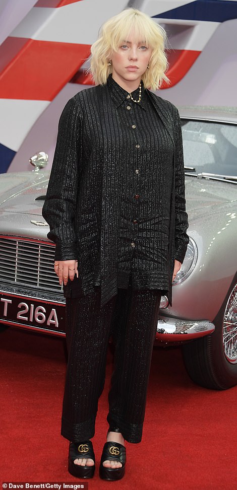 Billie Eilish, who wrote the No Time To Die theme song, eschewed a glamorous evening dress for a boxy black suit in a shimmering black fabric with matching shirt