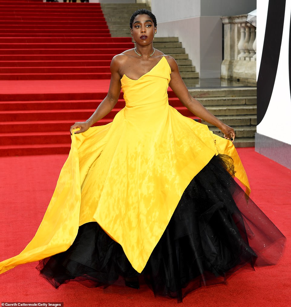 Bright and beautiful! Lashana Lynch stood out in a vibrant yellow Vivienne Westwood Couture ballgown with a voluminous black skirt and dramatic asymmetric neckline. She struck a pose as she walked the red carpet at the Royal Albert Hall