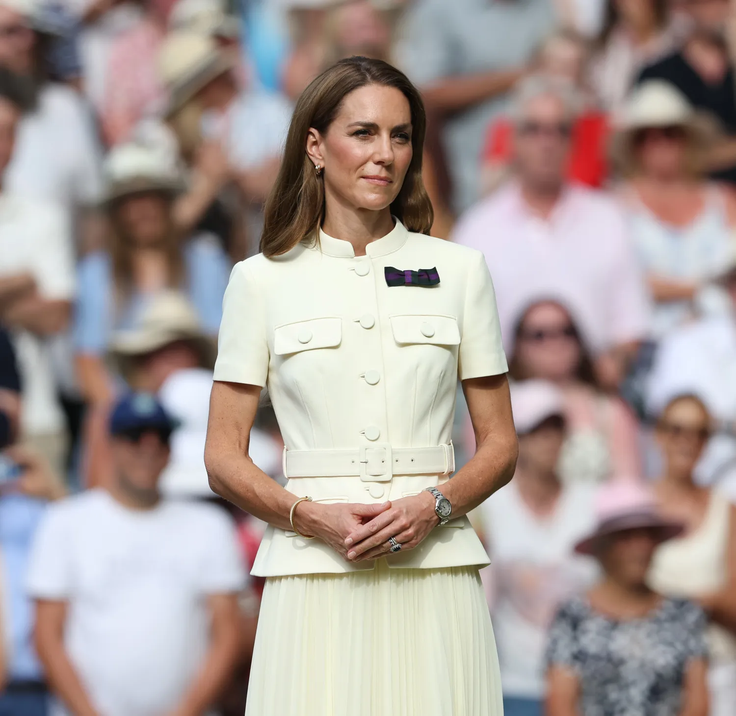 Kate Middleton standing outdoors surrounded by a crowd