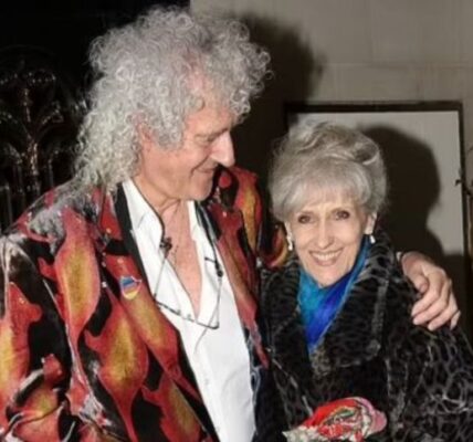 It Was Intended to Be a Private Celebration—Just Close Friends, Modest Toasts, and a Lifetime of Memories.  However, Magic Made Its Way Onto the Stage for the Wedding Anniversary of Brian May and Anita Dobson.  Love Was in the Air, Candles Were Low, and Adam Lambert and Roger Taylor Came Forward to Perform a Heart-Stopping Version of “Who Wants to Live Forever.”  Their Voices Rose Not in Grief but in Remembrance—To a Relationship Established in Music, to a Love That Has Lasted for Decades, and to the Man Whose Guitar Continues to Sing of Distant Worlds.