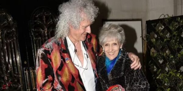 It Was Intended to Be a Private Celebration—Just Close Friends, Modest Toasts, and a Lifetime of Memories.  However, Magic Made Its Way Onto the Stage for the Wedding Anniversary of Brian May and Anita Dobson.  Love Was in the Air, Candles Were Low, and Adam Lambert and Roger Taylor Came Forward to Perform a Heart-Stopping Version of “Who Wants to Live Forever.”  Their Voices Rose Not in Grief but in Remembrance—To a Relationship Established in Music, to a Love That Has Lasted for Decades, and to the Man Whose Guitar Continues to Sing of Distant Worlds.