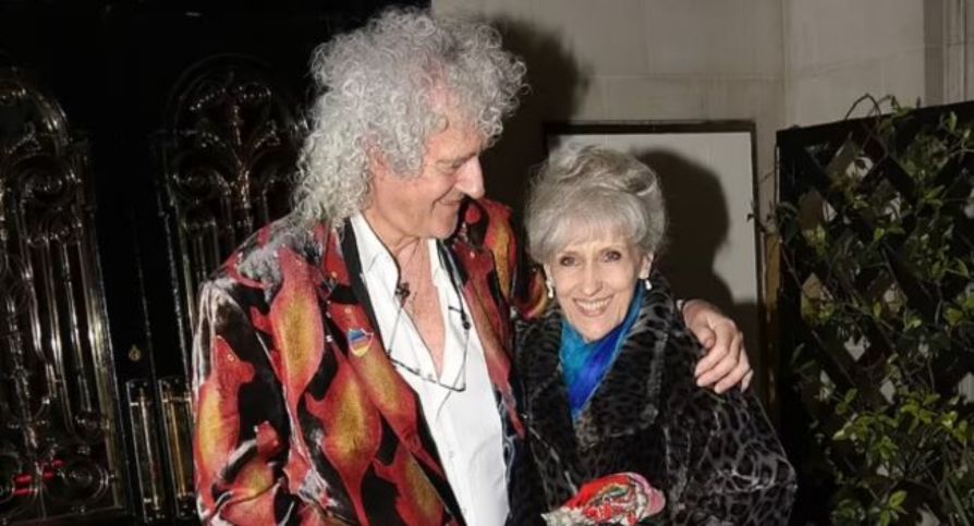 It Was Intended to Be a Private Celebration—Just Close Friends, Modest Toasts, and a Lifetime of Memories.  However, Magic Made Its Way Onto the Stage for the Wedding Anniversary of Brian May and Anita Dobson.  Love Was in the Air, Candles Were Low, and Adam Lambert and Roger Taylor Came Forward to Perform a Heart-Stopping Version of “Who Wants to Live Forever.”  Their Voices Rose Not in Grief but in Remembrance—To a Relationship Established in Music, to a Love That Has Lasted for Decades, and to the Man Whose Guitar Continues to Sing of Distant Worlds.
