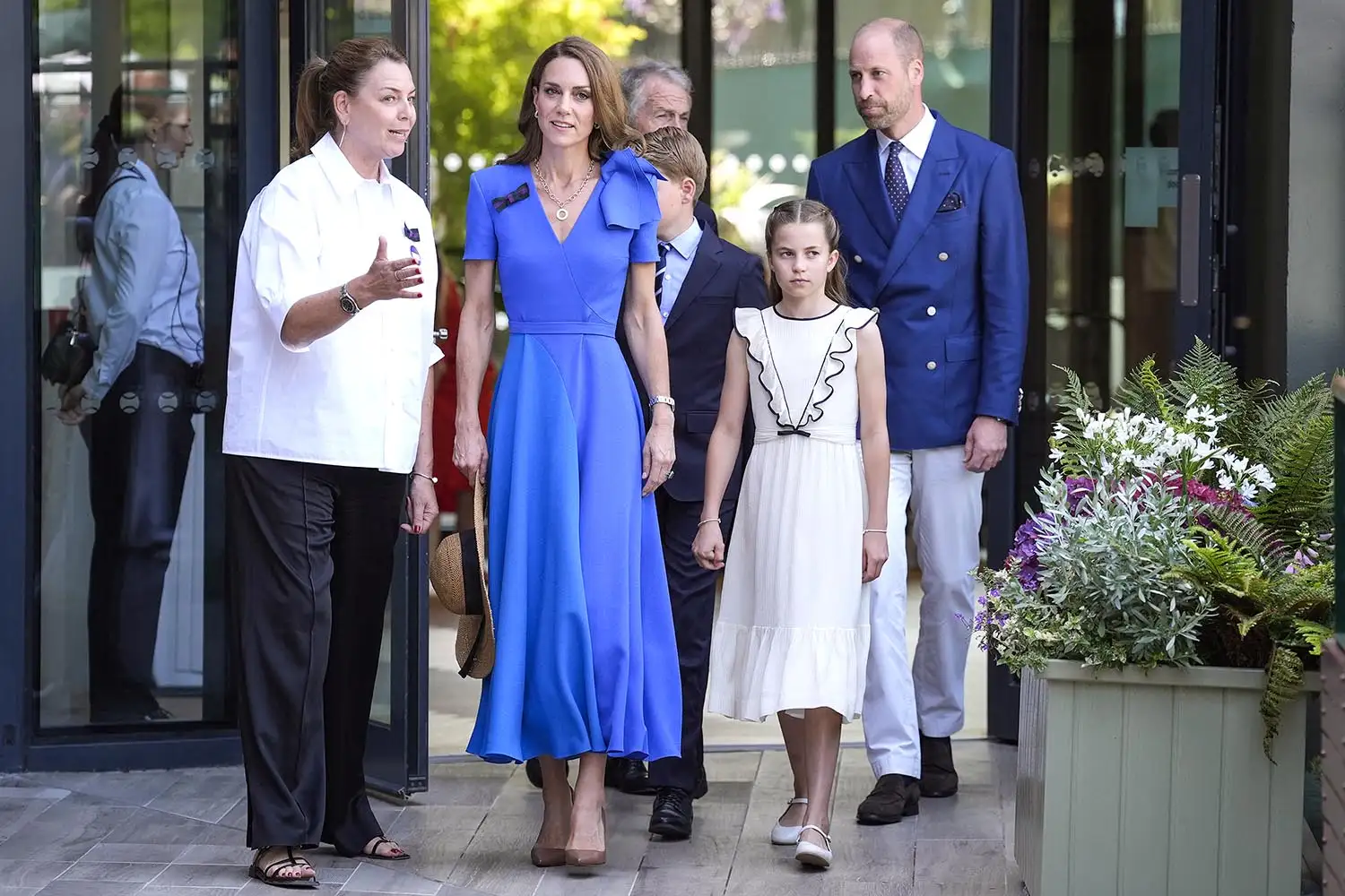 Catherine, Princess of Wales (front C), Britain's Princess Charlotte of Wales (front R), Britain's Prince William, Prince of Wales (rear r) are welcomed by member of the Committee of Management of The Championships Sally Ambrose (front L) upon their arrival to attend the men's singles final tennis match between Italy's Jannik Sinner and Spain's Carlos Alcaraz on the fourteenth day of the 2025 Wimbledon Championships at The All England Lawn Tennis and Croquet Club in Wimbledon, southwest London, on July 13, 2025.