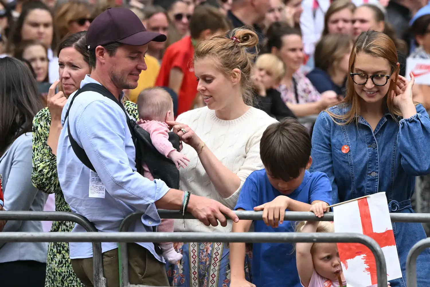 Britain's Princess Beatrice of York (C) her husband Edoardo Mozzi (CL) and children Sienna, Athena and Christopher joins fans lining the Mall waiting to greet the bus carrying the England women's national football team during the homecoming victory parade near Buckingham Palace in London on July 29, 2025 to celebrate the team winning Euro 2025