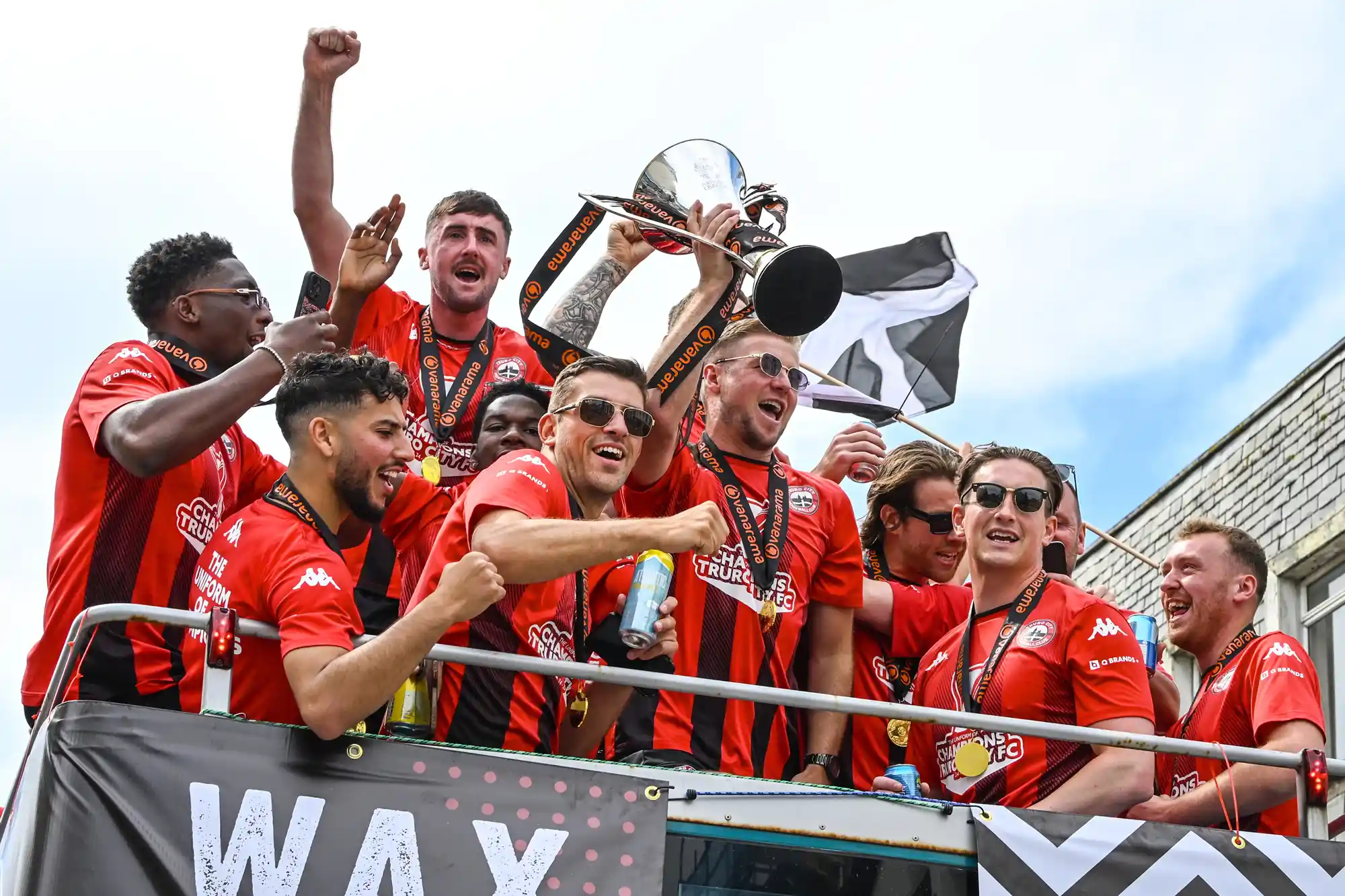 Truro City FC celebrate from an open top bus while it tours the streets of Truro as players and supporters gather to celebrate winning the National League South and their promotion to the National League on May 10, 2025