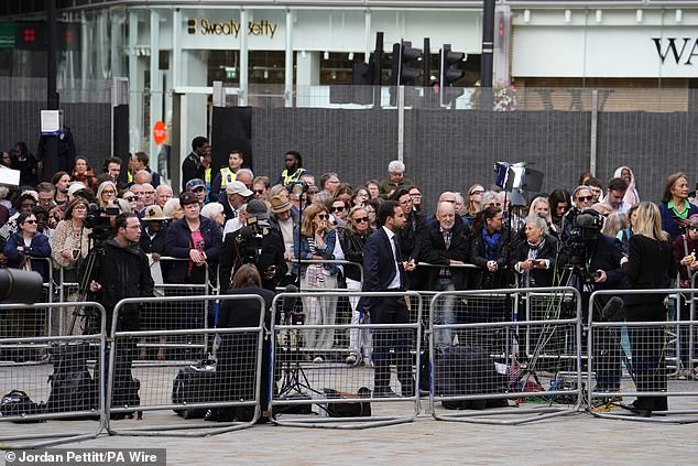 The public gather to watch arrivals for the requiem mass at Westminster Cathedral today