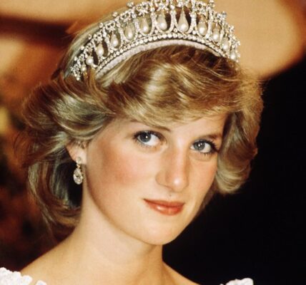“You were an angel in the shape of my mum…” The words barely left Prince William’s lips before his voice cracked — a soft, trembling whisper that carried across the candlelit Sunken Garden of Kensington Palace. Beside him, Prince Harry lowered his head, eyes glistening, as the brothers stood shoulder to shoulder on what would have been Princess Diana’s 64th birthday. There were no reporters, no speeches, no royal protocol. Just lanterns. Just family. Just two sons honoring the woman who changed the world. Then, in a moment no one saw coming, William nodded — and a piano began to play. Supermarket Flowers. But not the version the world knows. This one had been rewritten — quiet, aching lines shaped from their own memories: “You taught us grace long before we knew its name… You held our hands through storms the world never saw…” Their voices rose gently into the night, blending in a way they hadn’t in years. Behind them, soft projections flickered to life: Diana cradling children in hospitals, laughing with families in need, stepping fearlessly through landmine fields, her smile bright enough to warm a world she constantly tried to heal.
