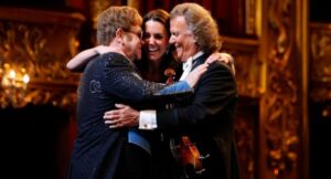 The Crowd Sobbed. The King Wept. And The Nation Held Its Breath. Under golden lights at the Royal Gala, Princess Kate played with quiet grace, André Rieu conducted with sweeping majesty, and Sir Elton John’s haunting rendition of “Your Song” brought the room to its knees. As King Charles wiped away tears, 10,000 guests stood frozen — some clasping hands, others overcome with emotion. Cameras captured tear-streaked faces, trembling lips, and royalty too moved to speak. The final chord echoed like a heartbeat across the hall. This wasn’t just music — it was history, love, and legacy colliding in one perfect, unforgettable night