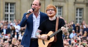 The Crowd Fell Silent As Prince William Walked Onto The Windsor Castle Stage Beside Ed Sheeran — No Announcement, No Fanfare, Just A Whispered Dedication: “For Dad, Mum, And Granny.” What Followed Was A Soul-Stirring Duet That Held 10,000 In Breathless Awe And Moved Millions Watching Around The World To Tears. William’s Voice, Steady Yet Choked With Feeling, Blended With Ed’s In A Heartbreaking Rendition Of “Thinking Out Loud,” Honoring King Charles, Princess Diana, And Queen Elizabeth II. Cameras Caught Princess Kate In The Front Row, Wiping Her Eyes As She Watched Her Husband Sing Not As A Prince, But As A Son, A Grandson — And A Man Carrying His Family’s Legacy In Song.