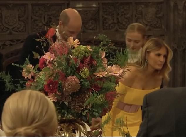 Prince William is pictured graciously pulling out a chair for First Lady Melania Trump during a glittering state banquet at Windsor Castle on Wednesday evening