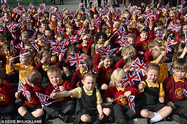 Pupils at Farnborough Road Infant and Junior School wave Union Jacks while waiting for the future King and Queen