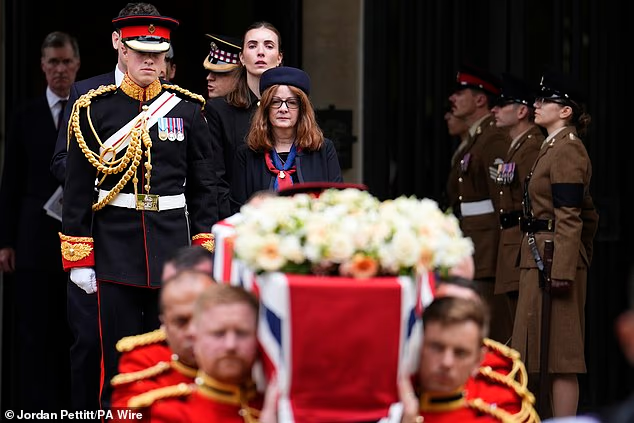 Family members watch as the Bearer Party carry the coffin from the funeral of Captain Godwin