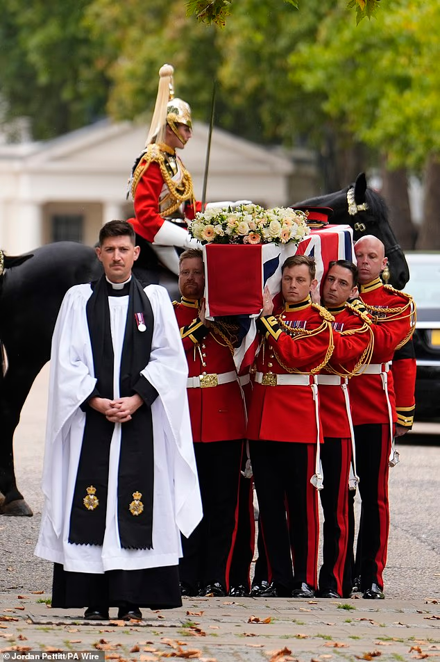 The Bearer Party carry the coffin in to the funeral for Captain Godwin
