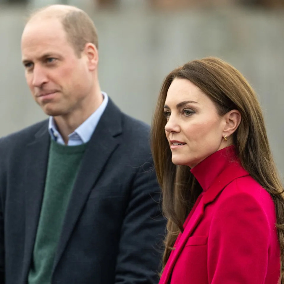  Prince William wears a navy coat and Kate Middleton wears a bright red coat and matching polo neck. 
