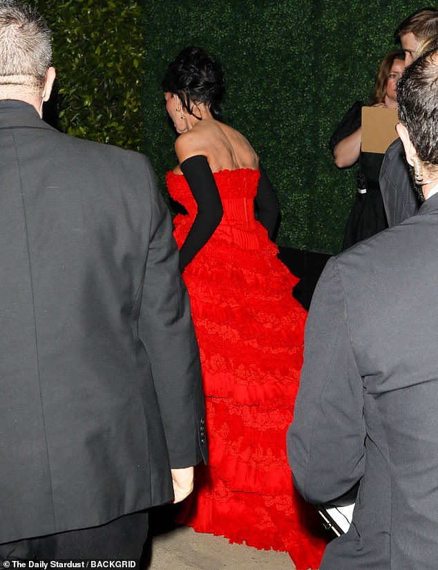 Kris was decked out in a sumptuous strapless crimson gown with a billowing skirt that featured cascading rows of frills, culminating in a train