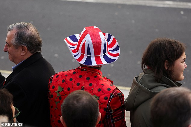A member of the public wears a Union Jack hat and a poppy jacket ahead of the Remembrance Sunday ceremony