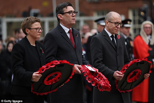Manchester Mayor Andy Burnham (C) lays a wreath during a Remembrance Sunday service