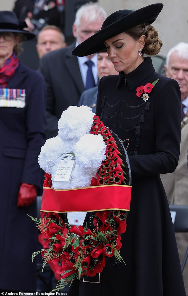 Kate holds a large wreath adorned with flowers and featuring a handwritten note from the royal