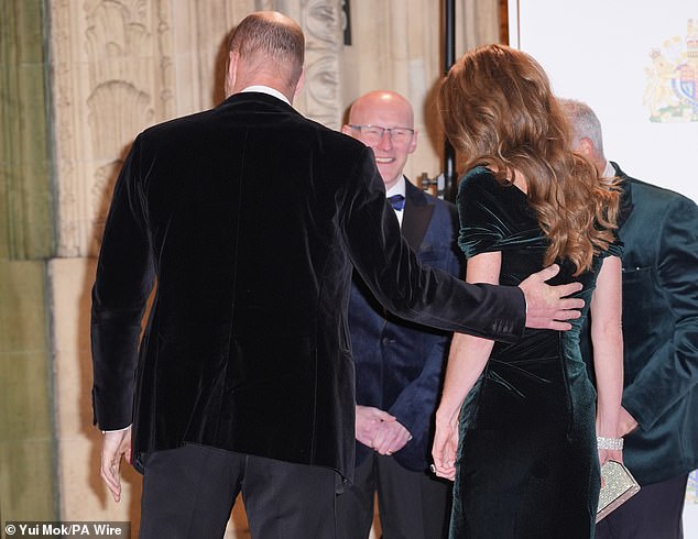 Once they had walked the length of the red carpet, William also reached over to put his hand on the small of Kate's back as they entered the venue together