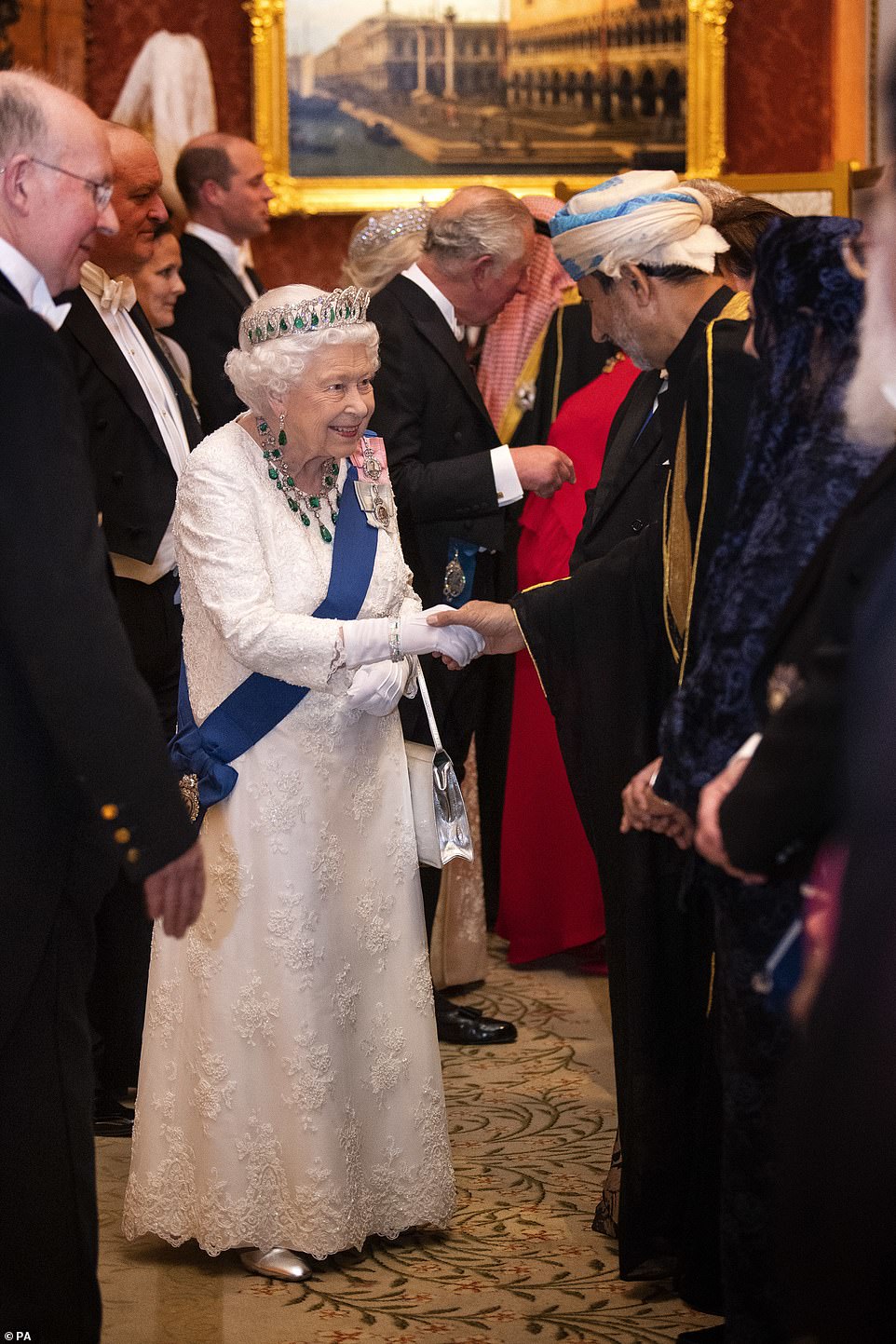 The monarch could be seen beaming as she took the hand of attendees at the reception at Buckingham Palace tonight