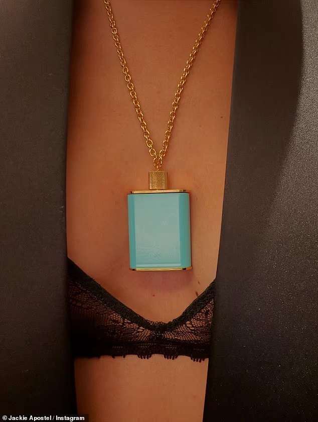 Jackie showed off her racy look, consisting of a black lace bra underneath a black blazer with a statement blue perfume bottle necklace