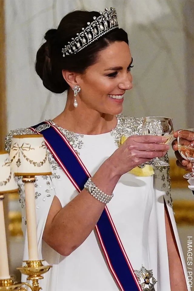 On November 2022, Catherine wore a white, caped, Jenny Packham gown for her first state dinner as Princess of Wales. She paired it with Queen Mary's Lover's Knot Tiara, Princess Diana's pearl