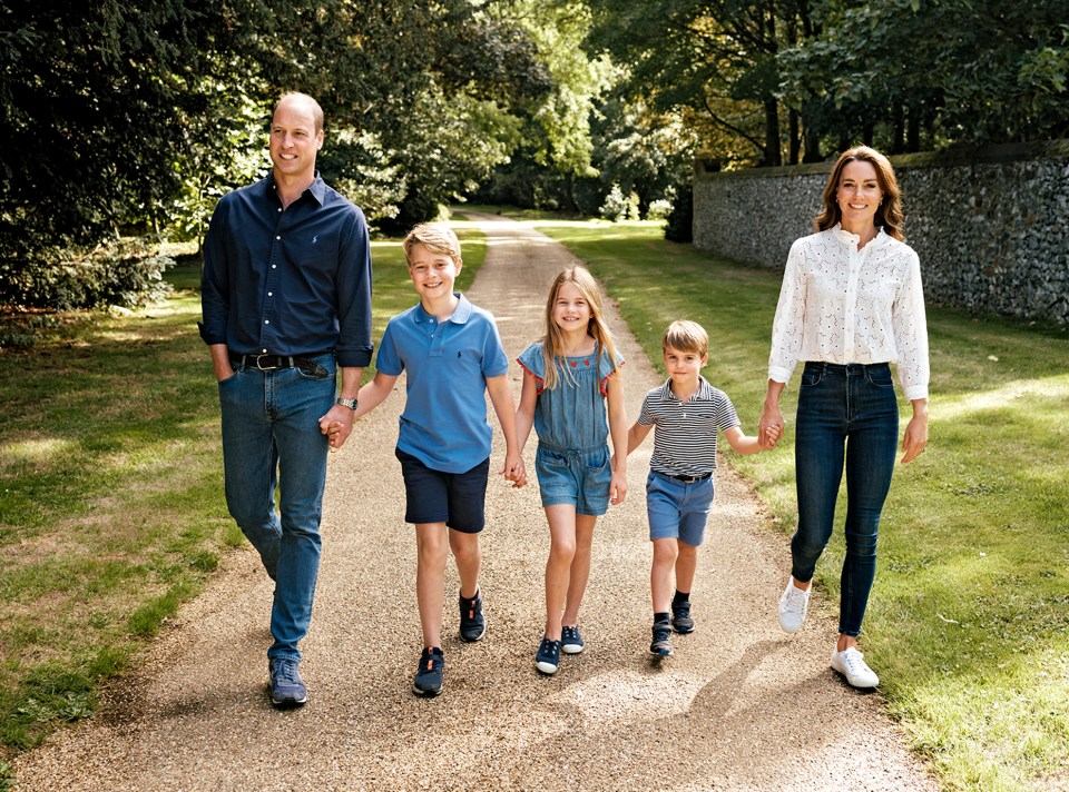 Photograph of Prince William, Catherine, Princess of Wales, and their three children walking down a path.