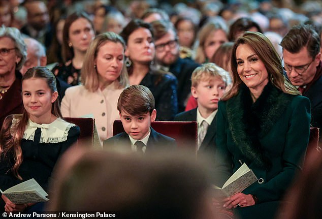 Kate sat next to her children - sporting an emerald winter coat - at the carol service this evening