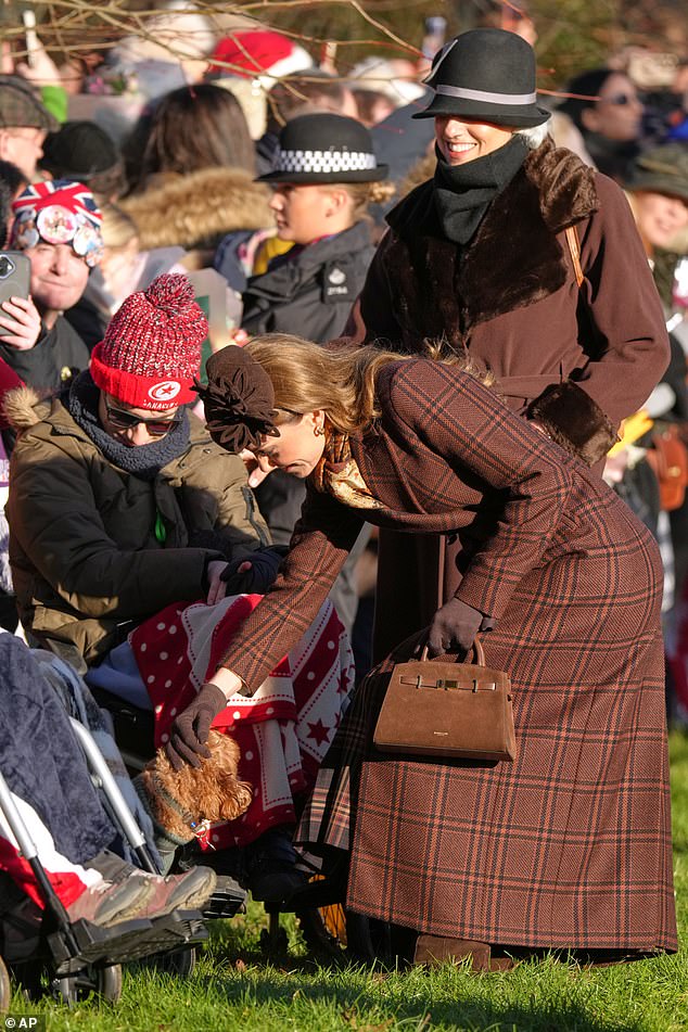 Catherine sweetly petting a dog while greeting members of the public outside the church