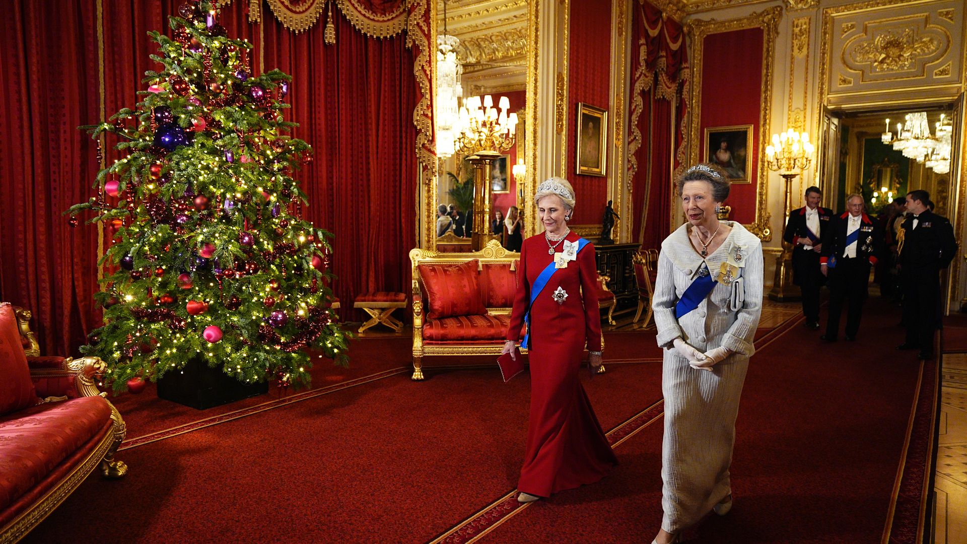 The Duchess of Gloucester and Princess Anne walking past a Christmas tree
