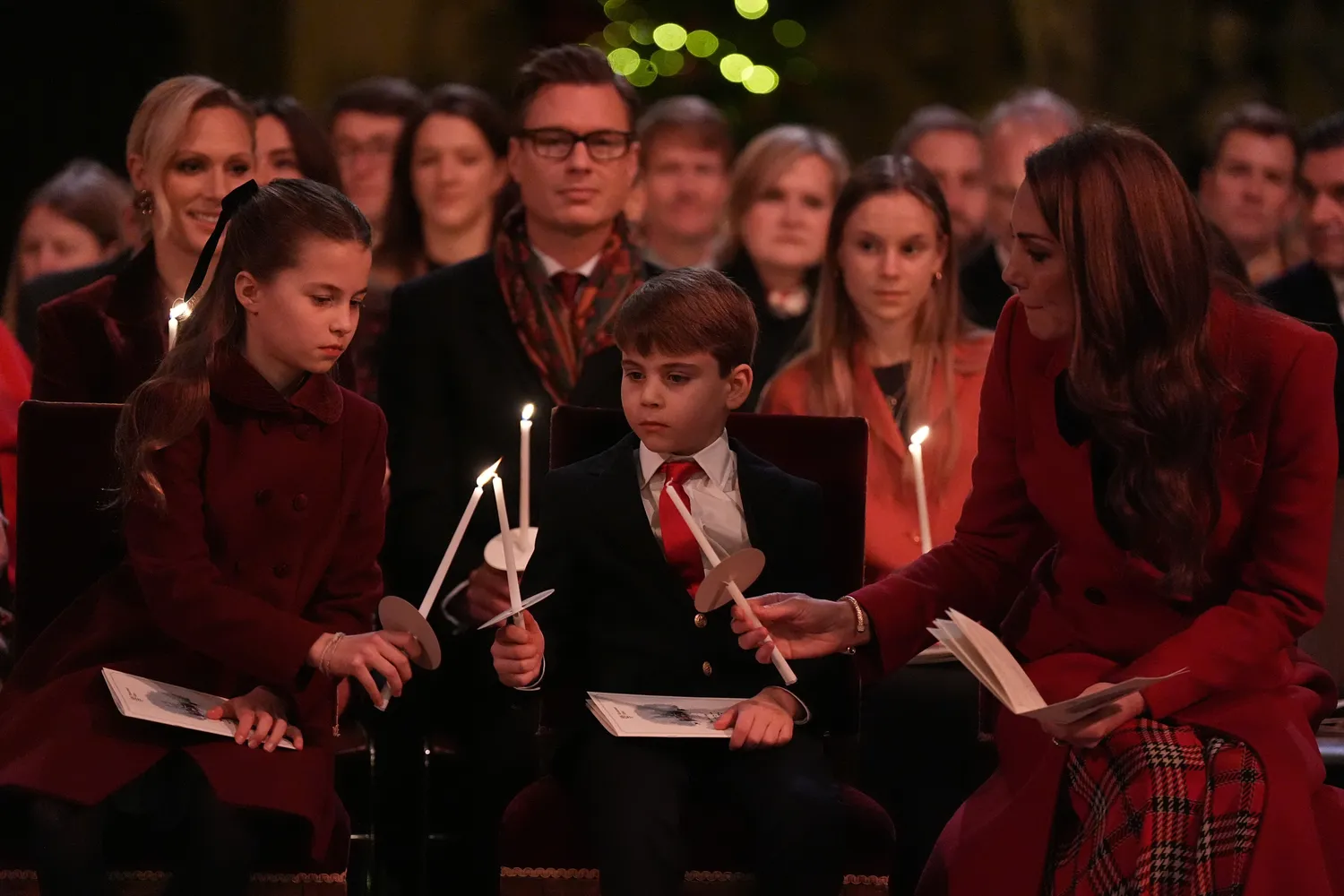 Kate Middleton helping Princess Charlotte and Prince Louis light candles during a carol service
