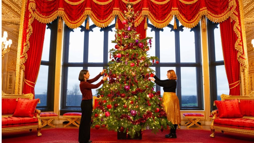 Two people decorating a Christmas tree