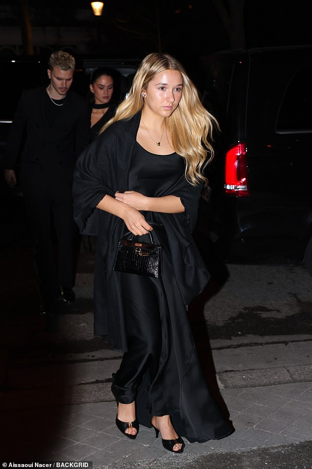 Harper followed her mother's lead by opting for a similar elegant black gown and a matching shawl for warmth