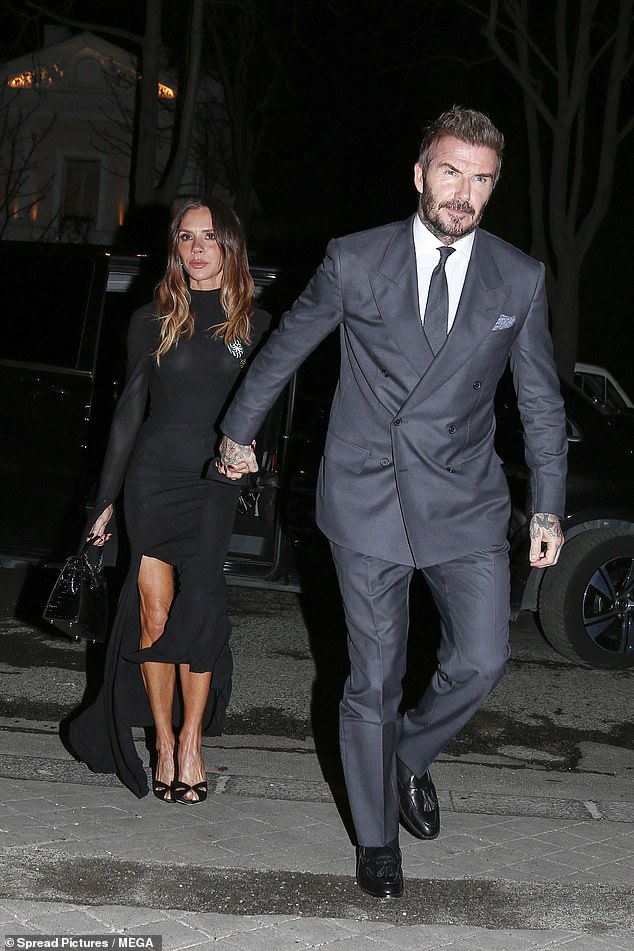 David held tightly onto his wife's hand as he led the way from the ceremony, cutting a dapper figure in a charcoal grey double-breasted suit