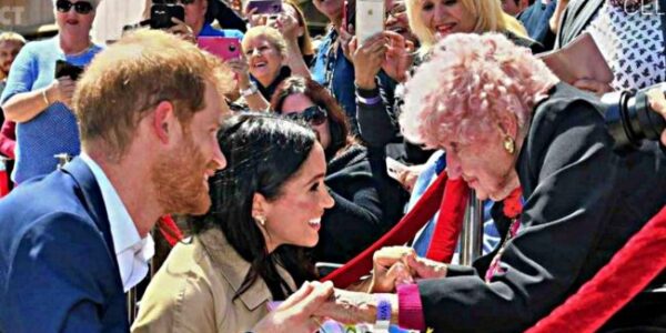 “Out of the entire crowd in Sydney, Harry wasn’t looking for cameras… he was looking for her.” Daphne Dunne was 98 — a war widow in a wheelchair, clutching flowers and carrying a lifetime of memories. The moment Harry spotted her, he went straight over, taking her hand like he’d found family, then introducing Meghan with unmistakable tenderness. It wasn’t a “royal” moment in the ceremonial sense — it was the kind that makes your throat tighten: some people aren’t famous, but their loyalty and their loss are heavy enough to quiet an entire crowd.