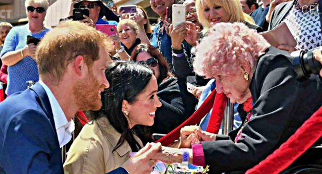 “Out of the entire crowd in Sydney, Harry wasn’t looking for cameras… he was looking for her.” Daphne Dunne was 98 — a war widow in a wheelchair, clutching flowers and carrying a lifetime of memories. The moment Harry spotted her, he went straight over, taking her hand like he’d found family, then introducing Meghan with unmistakable tenderness. It wasn’t a “royal” moment in the ceremonial sense — it was the kind that makes your throat tighten: some people aren’t famous, but their loyalty and their loss are heavy enough to quiet an entire crowd.