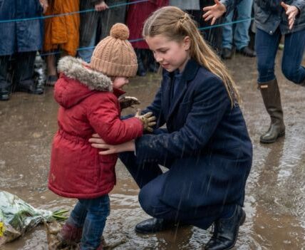 “Don’t worry, I’ve got you… it’s just a little rain.” The “Princess in the Rain”: A tiny, heart-melting detail in this photo of Princess Charlotte is going viral—can you spot it? There’s a reason the world is falling in love with this 10-year-old royal all over again. In a rare 5-minute moment captured by the Princess of Wales herself, Charlotte shows a side of her character that most people missed. Look at the way she connects with the toddler—there is one specific gesture that proves she’s a “Queen of Hearts” in the making.
