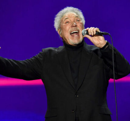 The arena went still — no coughs, no shuffling, no chatter — as Tom Jones repeated the line, his voice carrying decades of love, loss, and lessons learned. This wasn’t just a performance. It was a confession. First released in the late 1960s, I’ll Never Fall In Love Again was already a classic, but in Tom’s hands that night, it became something more — a living, breathing story. Each note trembled with vulnerability yet burned with the strength of someone who’s survived heartbreak and lived to tell it. The lush arrangement wrapped around him like a memory, the melody pulling the crowd through every high and low of love’s dangerous game. Some in the audience wiped away tears. Others simply sat frozen, afraid to break the spell. For those few minutes, it didn’t matter if you’d been in love, lost love, or just dreamed of it — you felt it. And when the final note faded, it left behind a silence that spoke louder than applause. Because some songs don’t just get sung… they get lived.